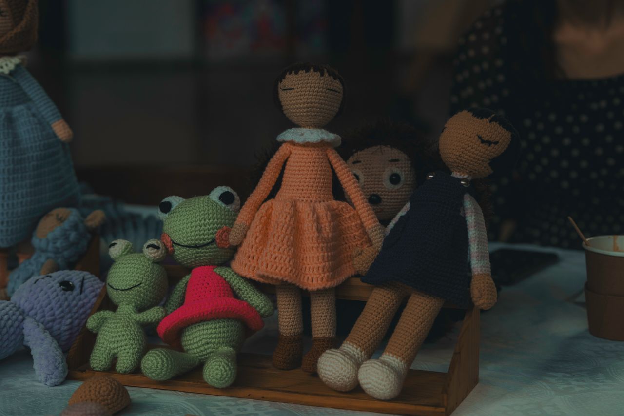 services-01 A delightful set of handmade knitted dolls and stuffed animals on display, showcasing intricate craftsmanship.